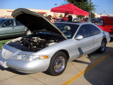 2000 Ford Crown Victoria - A silver Lincoln Mark VIII coupe is parked with its hood open, revealing the engine bay.