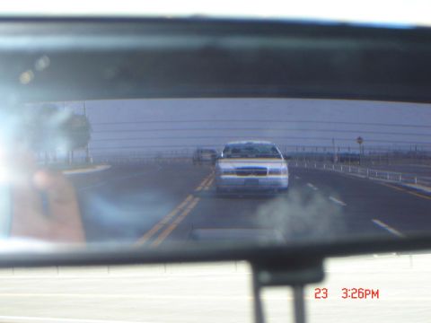1988 Ford LTD Crown Victoria - View of a 1992 Ford Crown Victoria from a rearview mirror on a highway.
