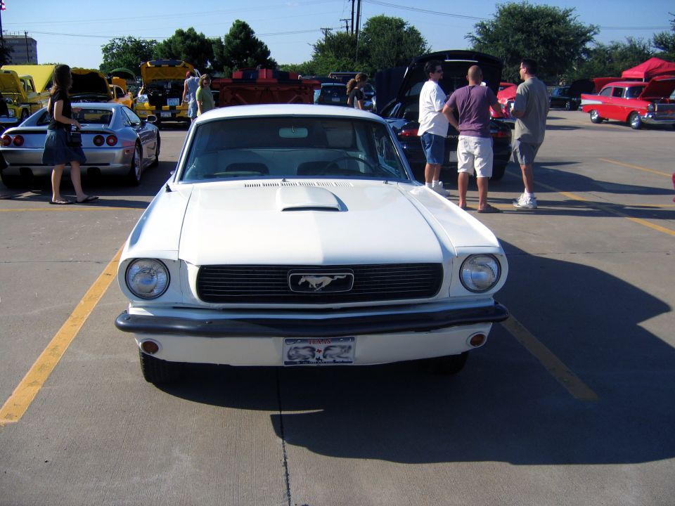 White 1965 Ford Mustang front view, parked at an outdoor car show