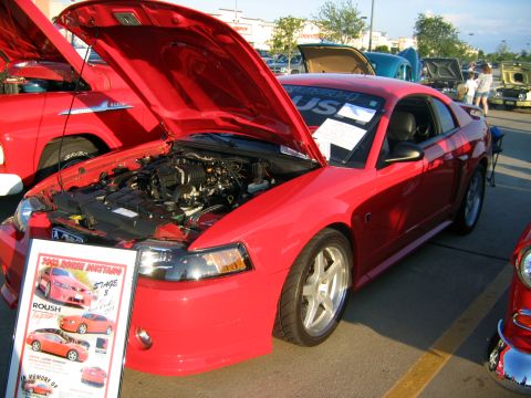2000 Ford Crown Victoria - A red 2003 Roush Mustang Stage 3 is displayed with its hood open at an outdoor car show.