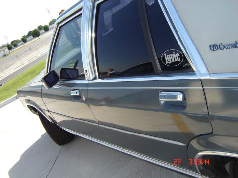 1988 Ford LTD Crown Victoria - Side profile of a 1988 Ford Crown Victoria LTD, chrome trim and a custom sticker on the rear passenger window.