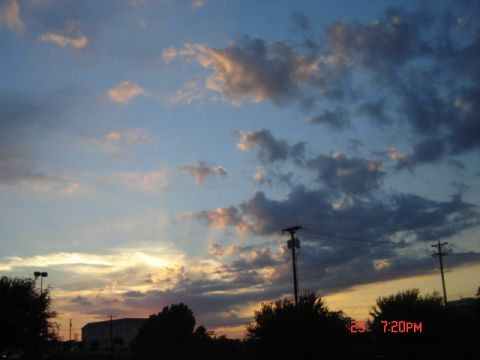 1988 Ford LTD Crown Victoria - Sunset sky with clouds, utility poles, and silhouetted trees and buildings. Watermark reads SUPERMOTORS.NET.