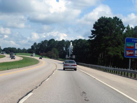 2000 Ford Crown Victoria - Driving on highway with a statue and food signs in view.