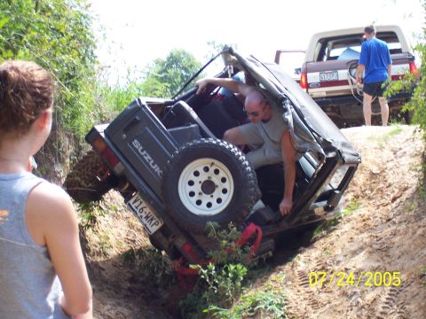 1987 Ford Bronco - A Suzuki Samurai is tipped on its side while a Ford Bronco waits in the background on July 24, 2005.