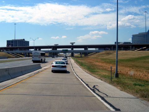 2000 Ford Crown Victoria - Vehicles travel on a highway under a bright blue sky with scattered clouds.