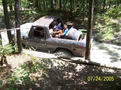 1987 Ford Bronco - A muddy 1978 Ford Bronco with occupants is stuck in a wooded area on July 24, 2005.