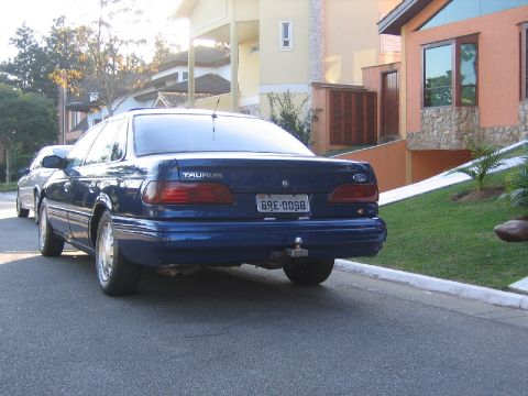1995 Ford Taurus - This blue Ford Taurus is parked on a residential street in front of a modern house.
