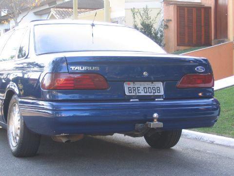 1995 Ford Taurus - Rear view of a blue 1995 Ford Taurus sedan with a trailer hitch and Brazilian license plate.