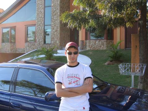 1995 Ford Taurus - A blue sedan is parked in front of a large house with a man standing next to it.