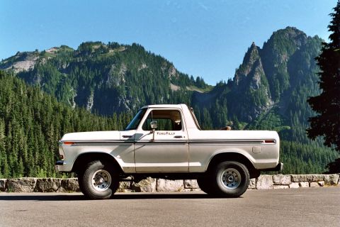 1979 Ford Bronco - This 1979 Ford Bronco is captured in profile against a backdrop of lush green mountains and a clear blue sky.