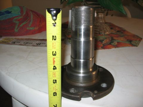 1995 Ford Bronco - A metal spindle is shown next to a yellow measuring tape, indicating its size.
