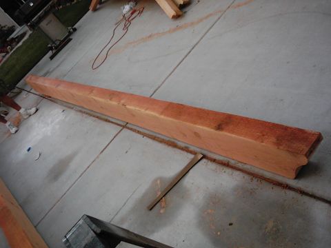 1978 Ford Bronco - A long wooden beam is on a concrete surface, with sawdust scattered around it.