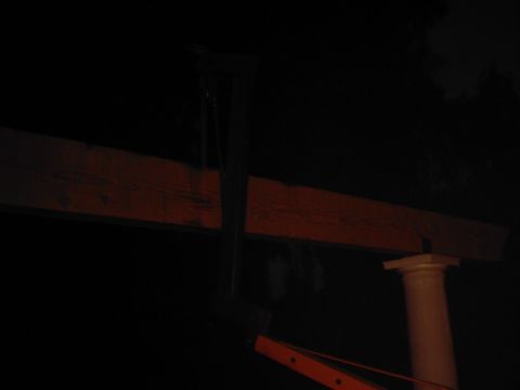 1978 Ford Bronco - A wooden beam is held up by a column, with an orange structure beneath it in the dark.