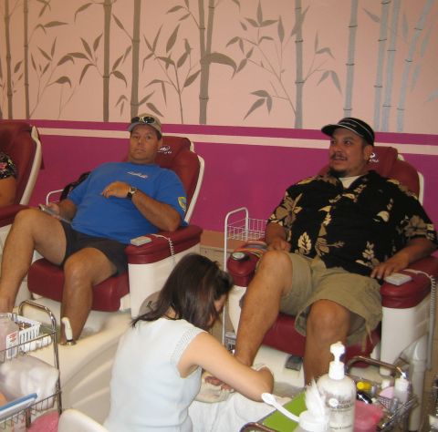 1985 Ford Mustang - Two men relax in pedicure chairs as a technician works on one of their feet.
