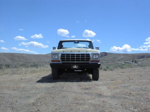 1979 Ford Bronco - This 1979 Ford Bronco is presented in a front-facing view against a backdrop of rolling hills and a bright blue sky.