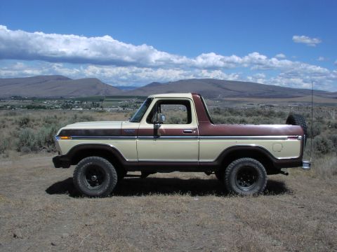 1979 Ford Bronco - This two-tone Ford Bronco is parked outdoors with a scenic landscape behind it.