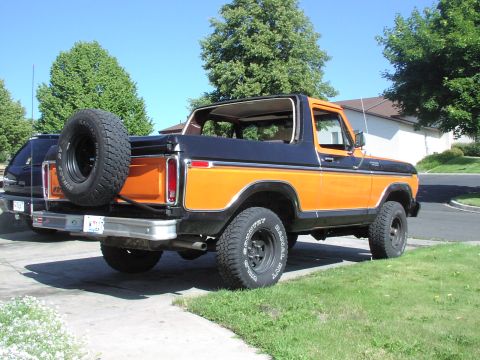1979 Ford Bronco - This 1979 Ford Bronco features a two-tone orange and black paint scheme and a rear-mounted spare tire.