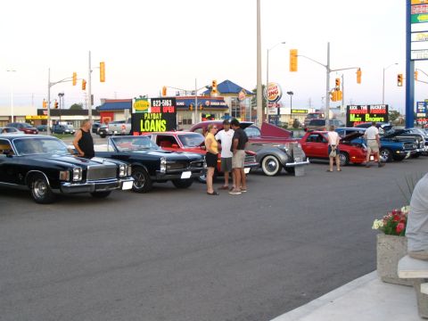 1993 Ford Taurus - A gathering of vintage automobiles outside a Burger King, with a payday loan business visible.