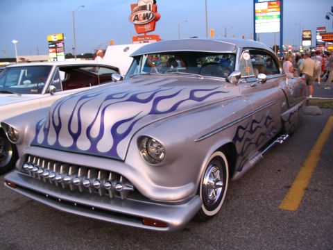 1993 Ford Taurus - A silver custom hot rod with purple flame graphics and a distinctive chrome grille is seen at an A&W cruise night.