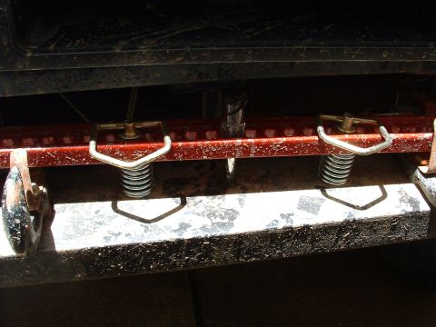 1993 Ford Bronco - Close-up of a Hi-lift jack attached to a vehicle's frame, showing its mounting hardware.