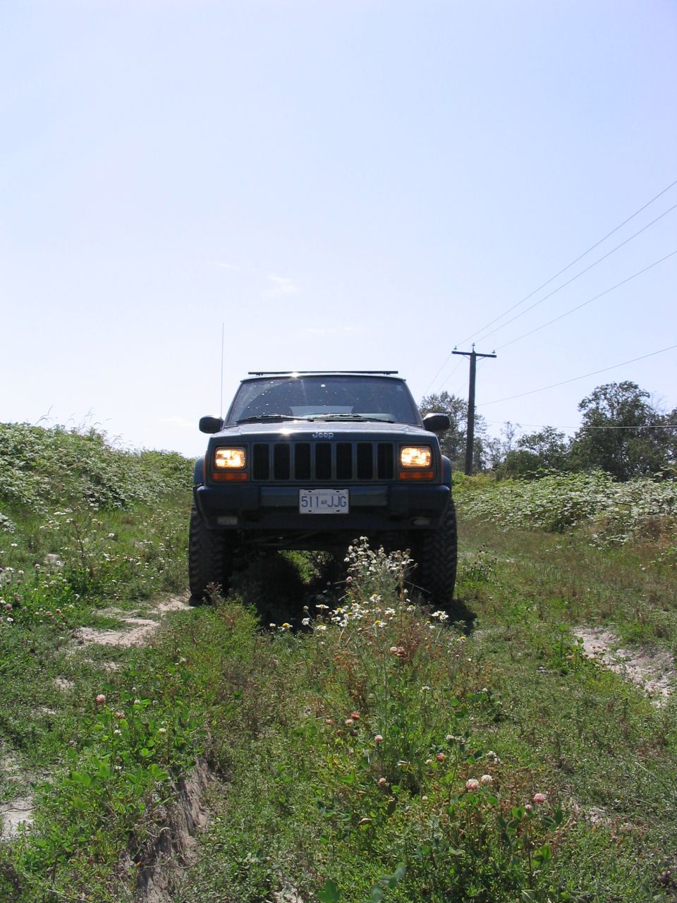 2000 Jeep Cherokee front view on a grassy dirt road
