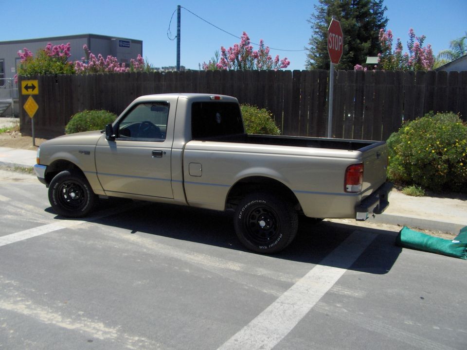 Tan Ford Ranger regular-cab pickup parked by stop sign