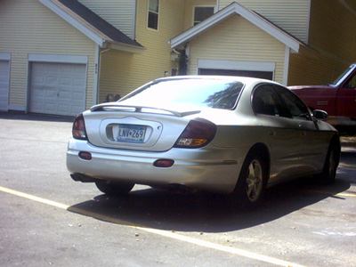 2002 Oldsmobile Aurora - Rear view of a silver 2002 Oldsmobile Aurora sedan, identifiable by its distinct taillights and spoiler.