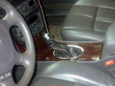 2002 Oldsmobile Aurora - Interior view of a 2002 Oldsmobile Aurora, focusing on the gear shifter and wood grain trim on the center console.