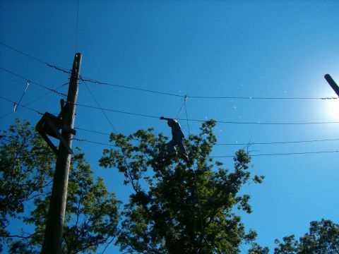 1995 Ford Bronco - A person walks across a wire suspended between utility poles under a clear blue sky.