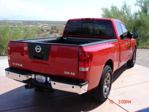 2005 Nissan Titan - Rear view of a red 2005 Nissan Titan pickup truck parked outdoors.
