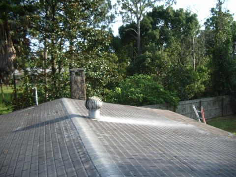 1978 Ford Bronco - A residential roof features a chimney and a turbine vent, with trees and a fence visible behind it.