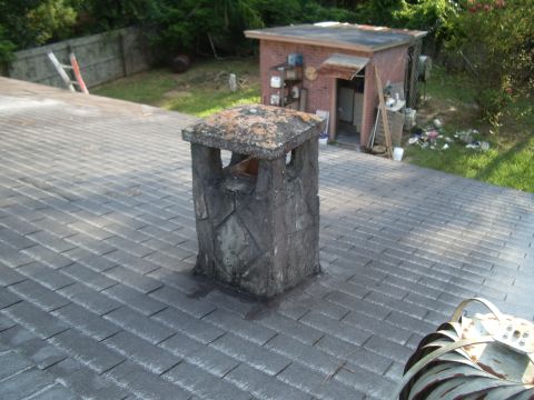 1978 Ford Bronco - A weathered chimney stands on a rooftop, with a small brick building and yard visible behind it.