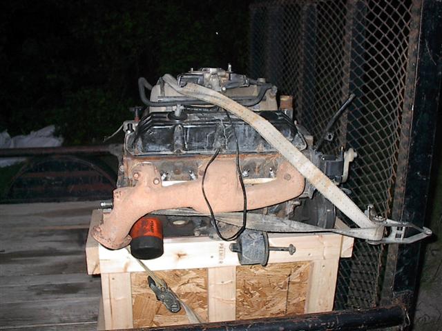engine on a wooden pallet, secured with straps, in a trailer