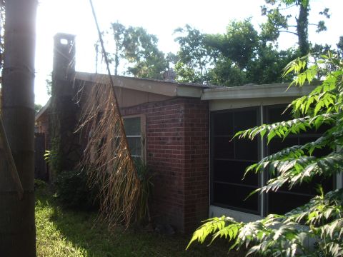 1978 Ford Bronco - Exterior view of a house brick construction and a screened-in porch area, surrounded by greenery.