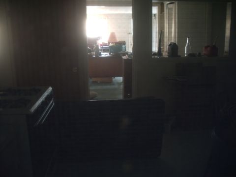 1978 Ford Bronco - A dimly lit interior scene shows a doorway leading to another room with a desk and lamp, along with various objects on a shelf.