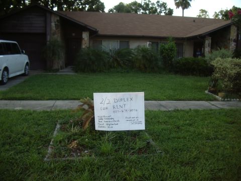 1978 Ford Bronco - A white van is parked in the driveway of a house with a 'For Rent' sign in the yard.