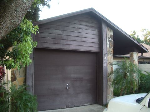 1978 Ford Bronco - A house features a large brown garage door flanked by stone pillars, with the address 5776 clearly visible.