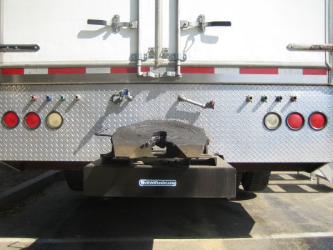 1990 Ford Bronco - rear of a box trailer shows a greased fifth-wheel plate, diamond-plate panel, lights, and a TheWebWheeler.com sticker.