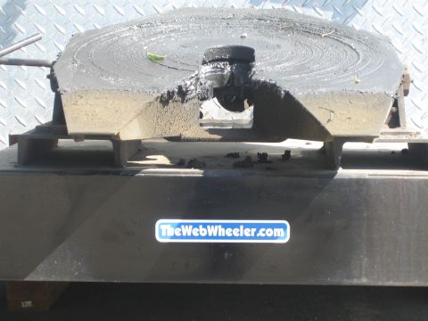 1990 Ford Bronco - close-up of a grease-coated fifth-wheel coupling plate above a bumper bearing a TheWebWheeler.com sticker.