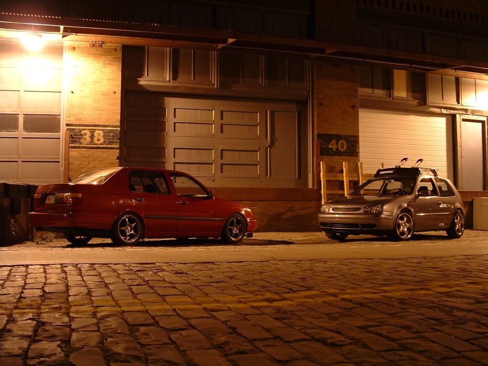 Silver hatchback with roof rack parked at night