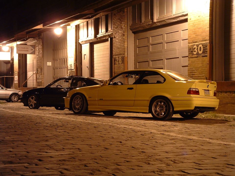 Yellow coupe parked at night, 3/4 front view. Appears to be a 1994 model