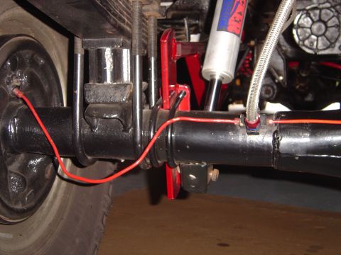 1978 Ford Bronco - This image focuses on the rear axle and suspension system of a vehicle, with visible shock absorber and brake lines.