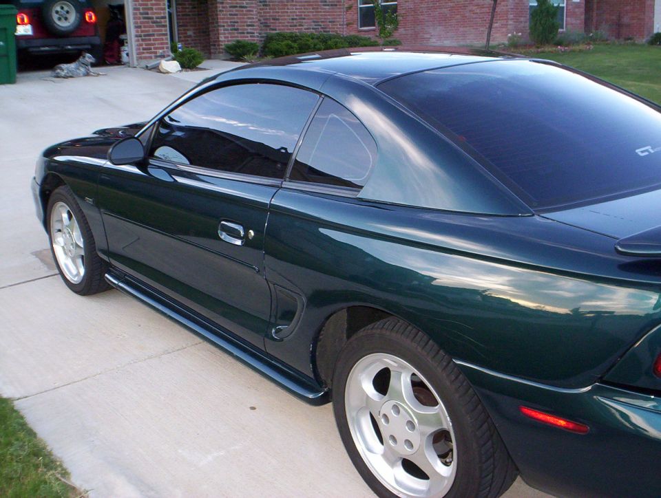 Dark green 1994 Ford Mustang coupe, rear quarter view. GT badge visible on rear quarter panel