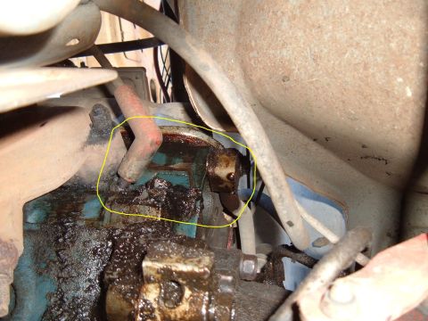 1989 Ford Bronco - Engine part showing an oil leak, likely from a gasket or seal.