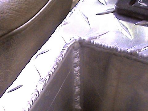 1978 Ford Bronco - This is a close-up of a diamond plate aluminum corner with visible welds and the Supermotors.net logo.