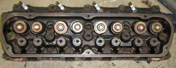 Used cast-iron V8 cylinder head rocker-side up showing eight valve springs and retainers