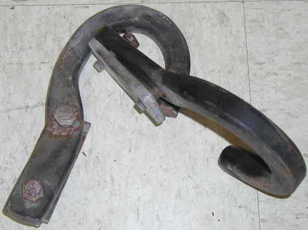 Pair of forged steel tow hooks with frame brackets and rusty bolts