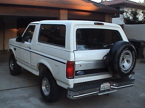 1994 Ford Bronco - This white Ford Bronco is seen from the rear, showing its spare tire and chrome bumper.