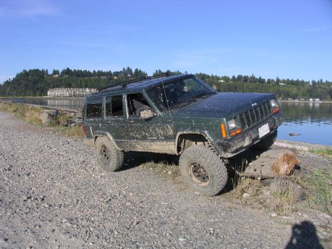 2000 Jeep Cherokee - Jeep Cherokee navigating a rough, muddy path near the water's edge.