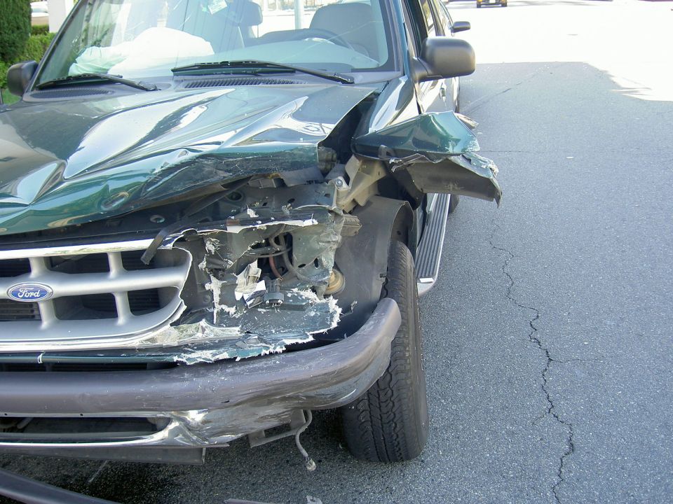 Green 1996 Ford Explorer with crumpled front end and deployed airbags